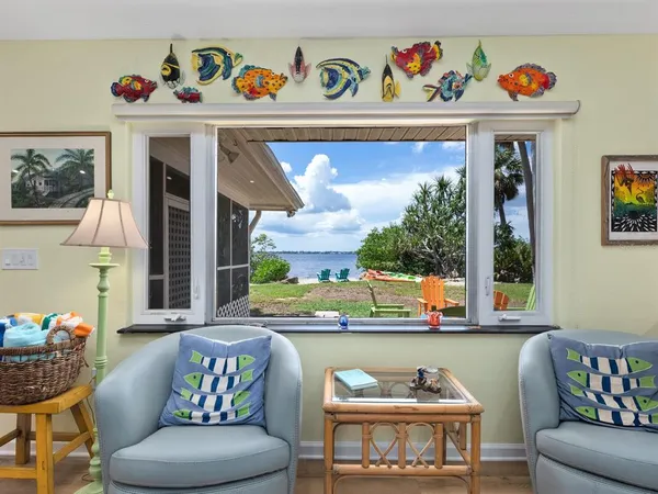 a living room with furniture kitchen view and a wooden floor