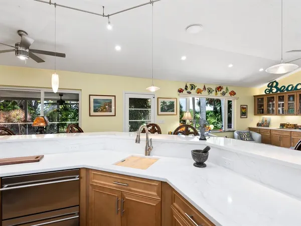 a kitchen with stainless steel appliances kitchen island granite countertop a table chairs and a refrigerator