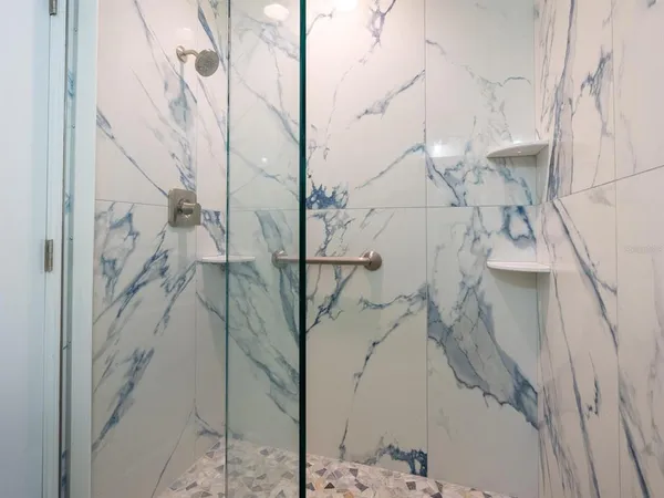 a bed sitting in a spacious bedroom next to a large window with garden view