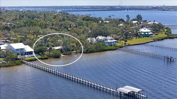 a view of a dining room and livingroom with furniture wooden floor a chandelier