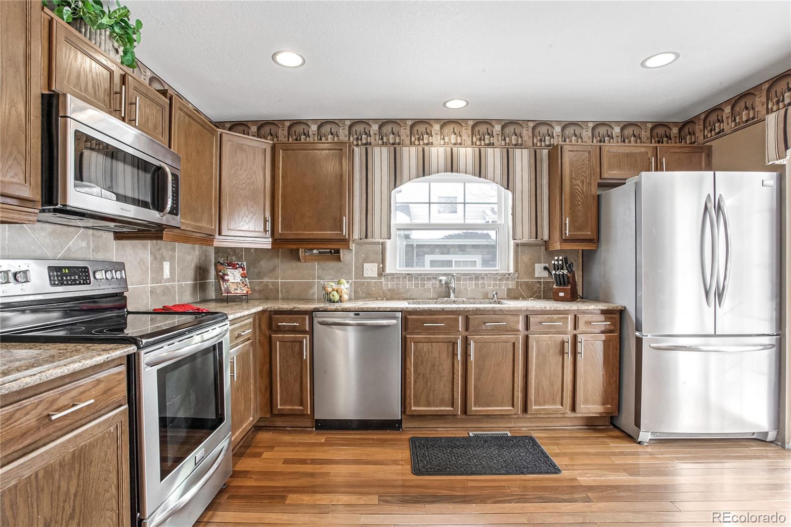 10106 North Grove Loop, Unit A Westminster, CO 80031 - Photo 9 of 33 a kitchen with stainless steel appliances a refrigerator stove and microwave