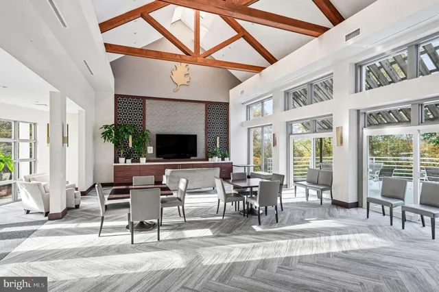 a living room with furniture a flat screen tv and a floor to ceiling window