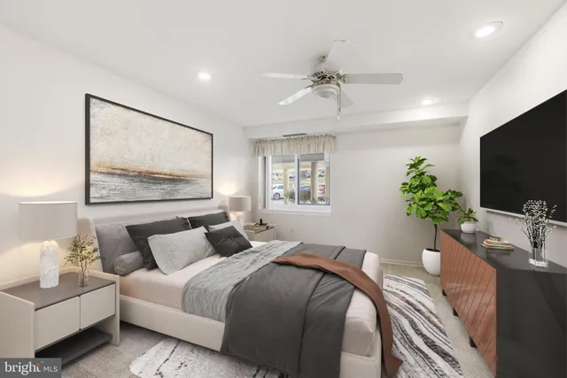 a bedroom with a bed a couch and a flat screen tv