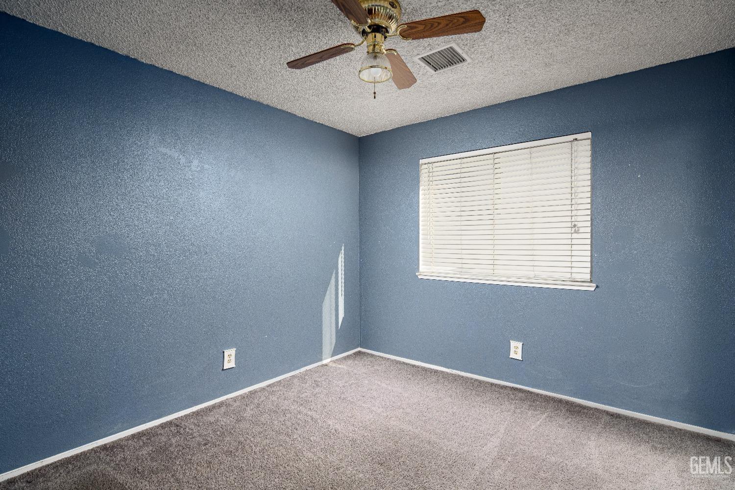Undisclosed Address Bakersfield, CA 93313 - Photo 11 of 17 an empty room with chandelier fan and windows