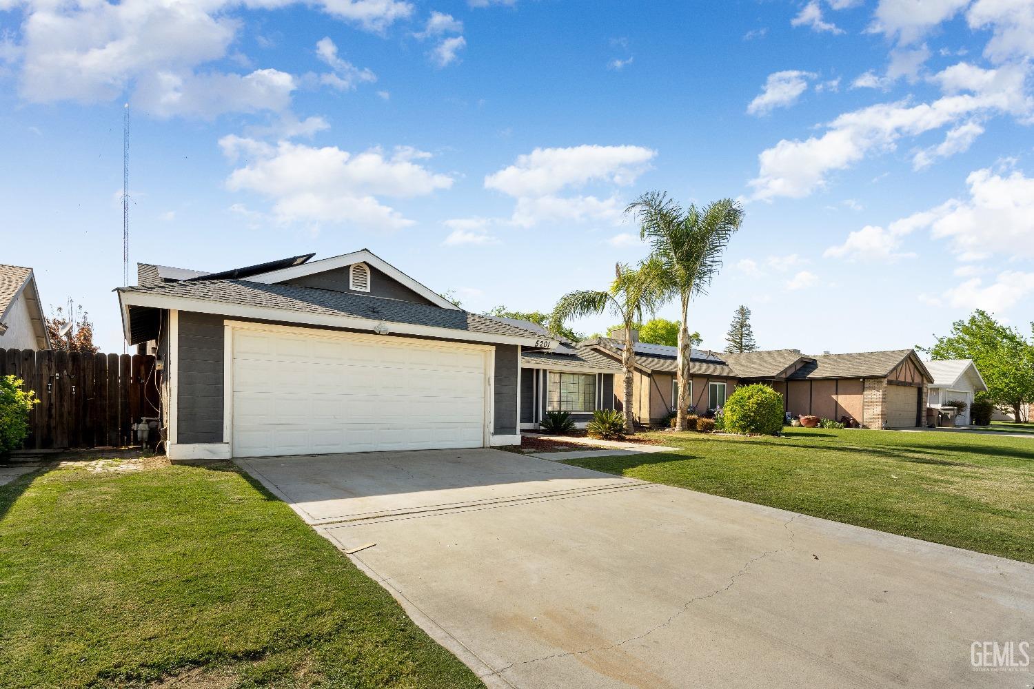 Undisclosed Address Bakersfield, CA 93313 - Photo 3 of 17 a front view of a house with a yard and garage