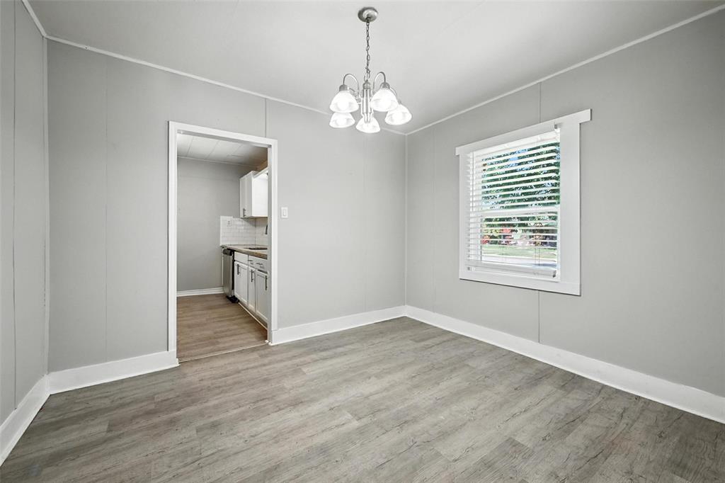 204 Graham Avenue Bonham, TX 75418 - Photo 5 of 21 Unfurnished dining area featuring light wood-style flooring, a chandelier, and crown molding