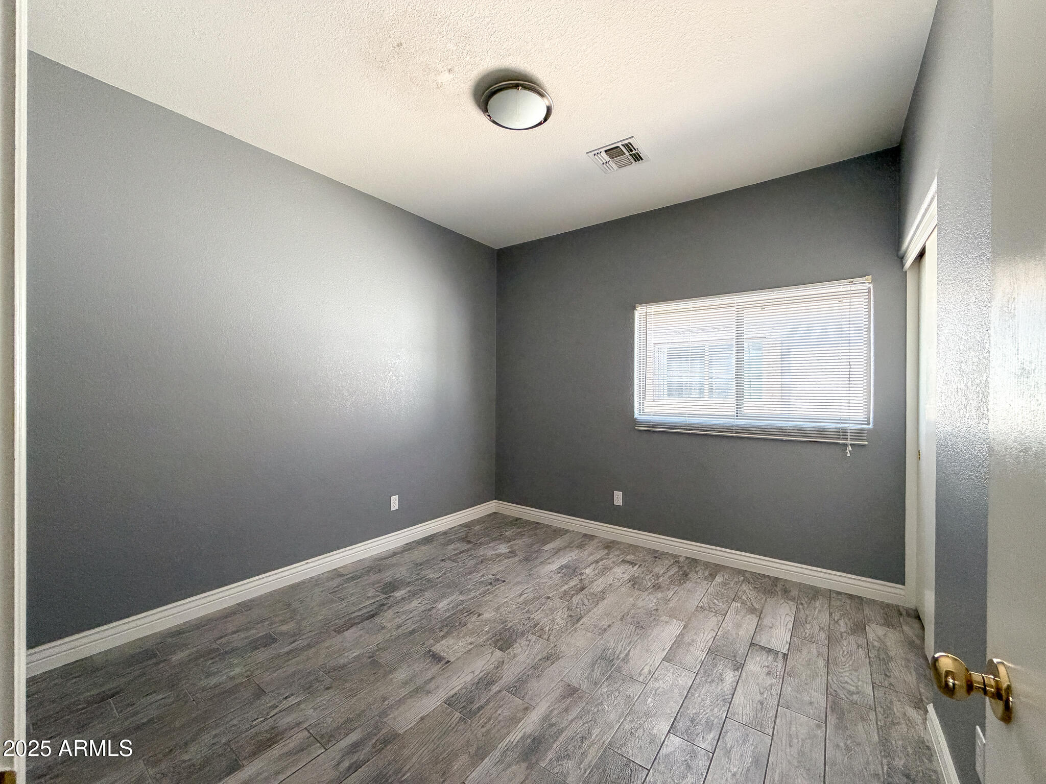 982 East Doris Street Avondale, AZ 85323 - Photo 12 of 17 a view of empty room with wooden floor