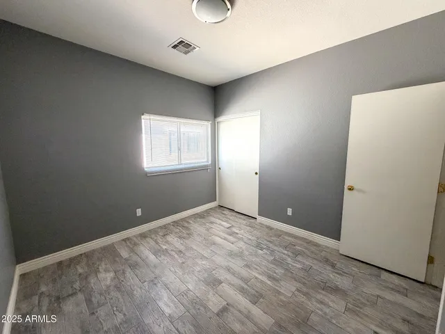 an empty room with wooden floor and window