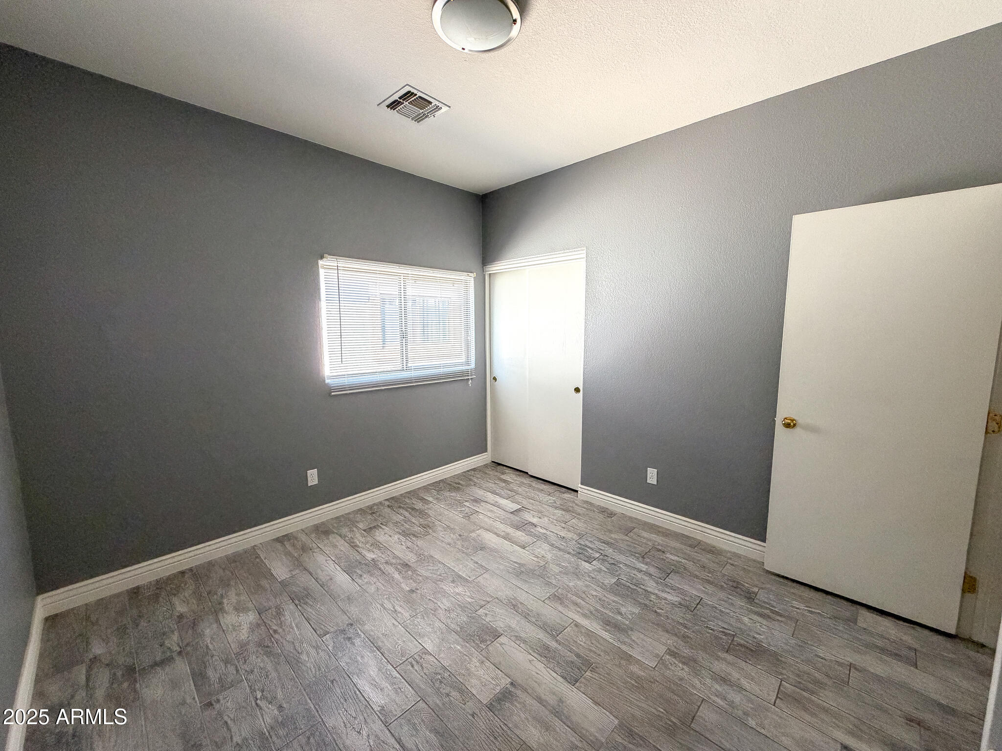 982 East Doris Street Avondale, AZ 85323 - Photo 13 of 17 an empty room with wooden floor and window