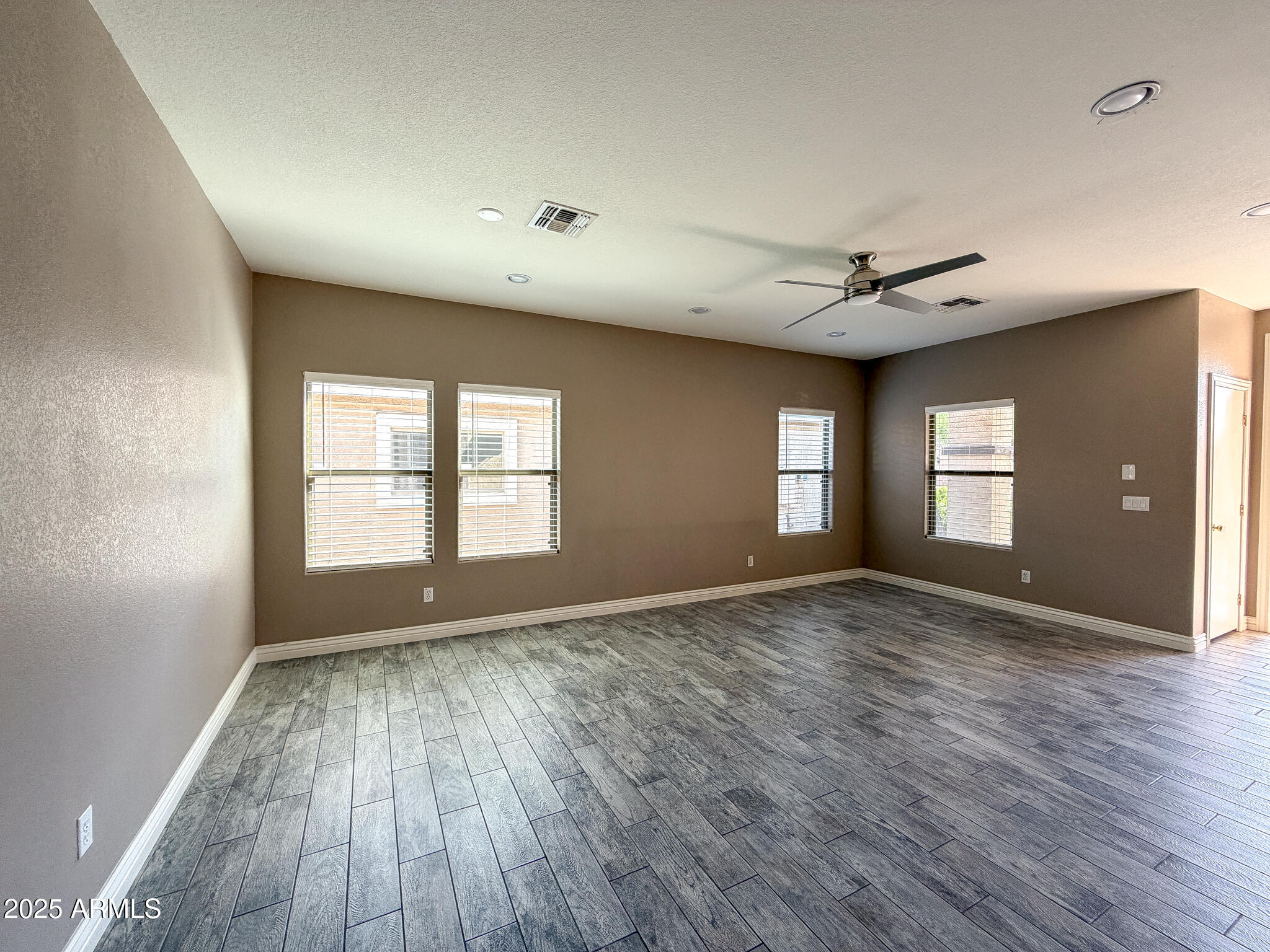 982 East Doris Street Avondale, AZ 85323 - Photo 4 of 17 a view of empty room with wooden floor and fan