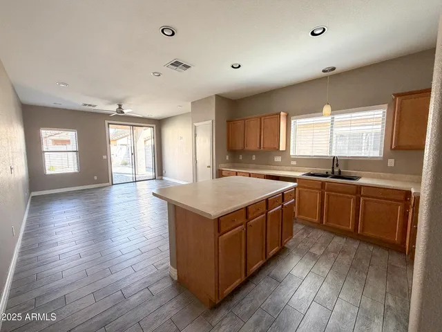 a kitchen with stainless steel appliances granite countertop a stove a sink a refrigerator and wooden floor