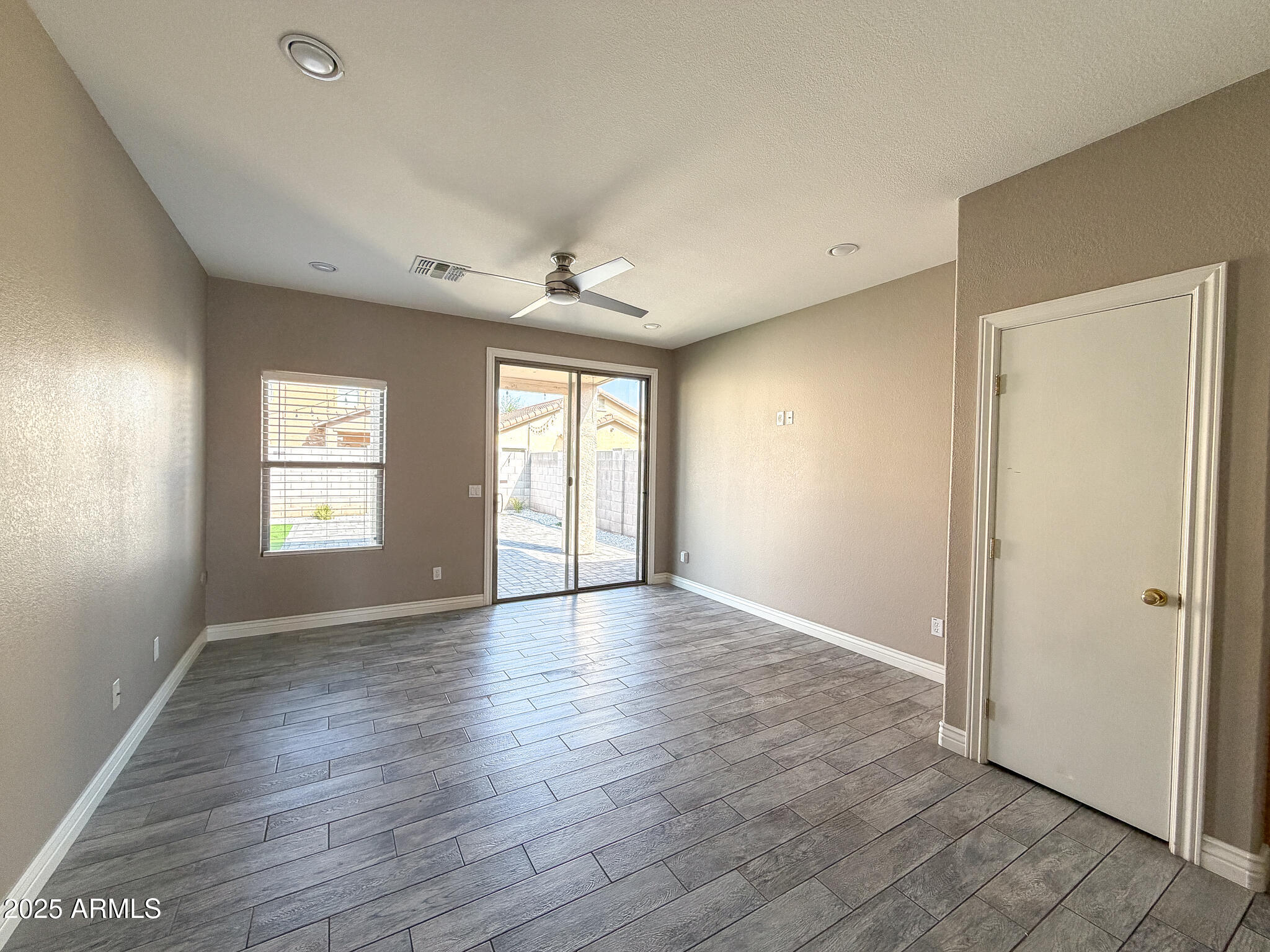 982 East Doris Street Avondale, AZ 85323 - Photo 8 of 17 an empty room with wooden floor and windows