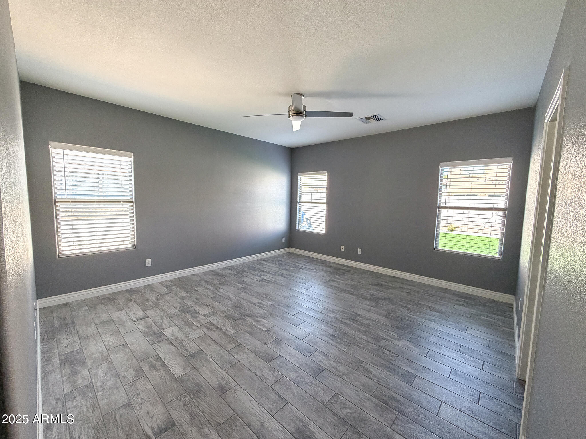 982 East Doris Street Avondale, AZ 85323 - Photo 9 of 17 an empty room with wooden floor and windows