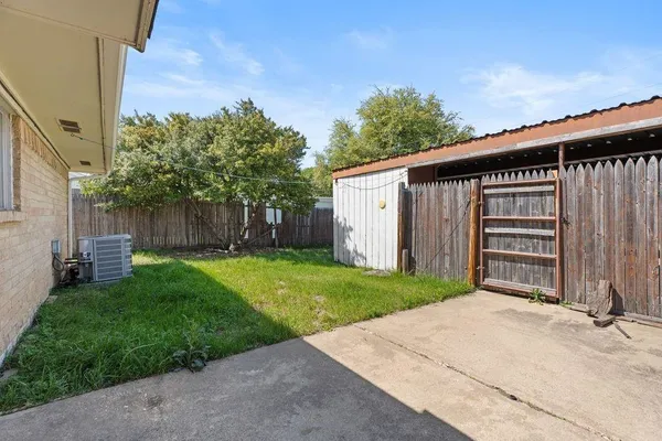 a backyard of a house with grass and a fence