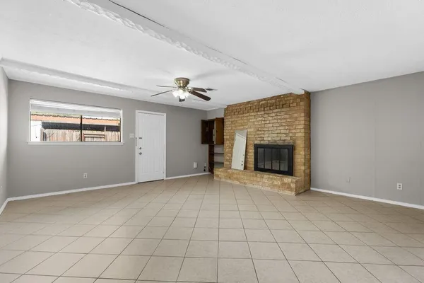 a view of an empty room with a fireplace and a window