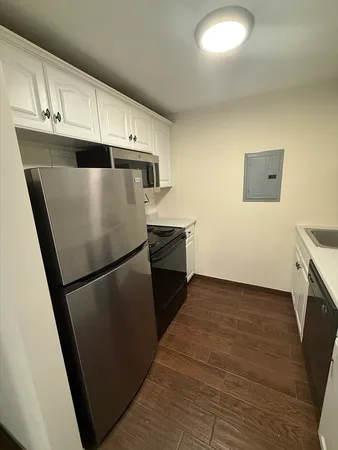 a kitchen with granite countertop white cabinets and white appliances