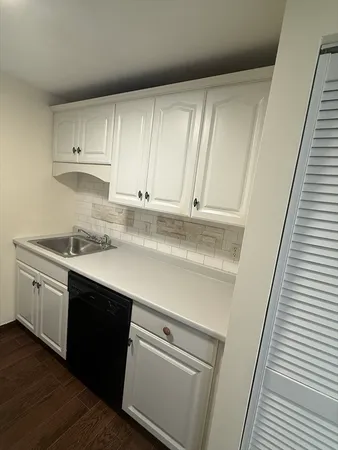 a kitchen with a sink a refrigerator freezer a stove and cabinets