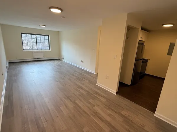 a view of a room with wooden floor and window