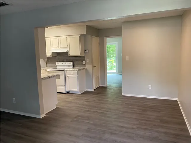 a view of a kitchen with wooden floor and a sink