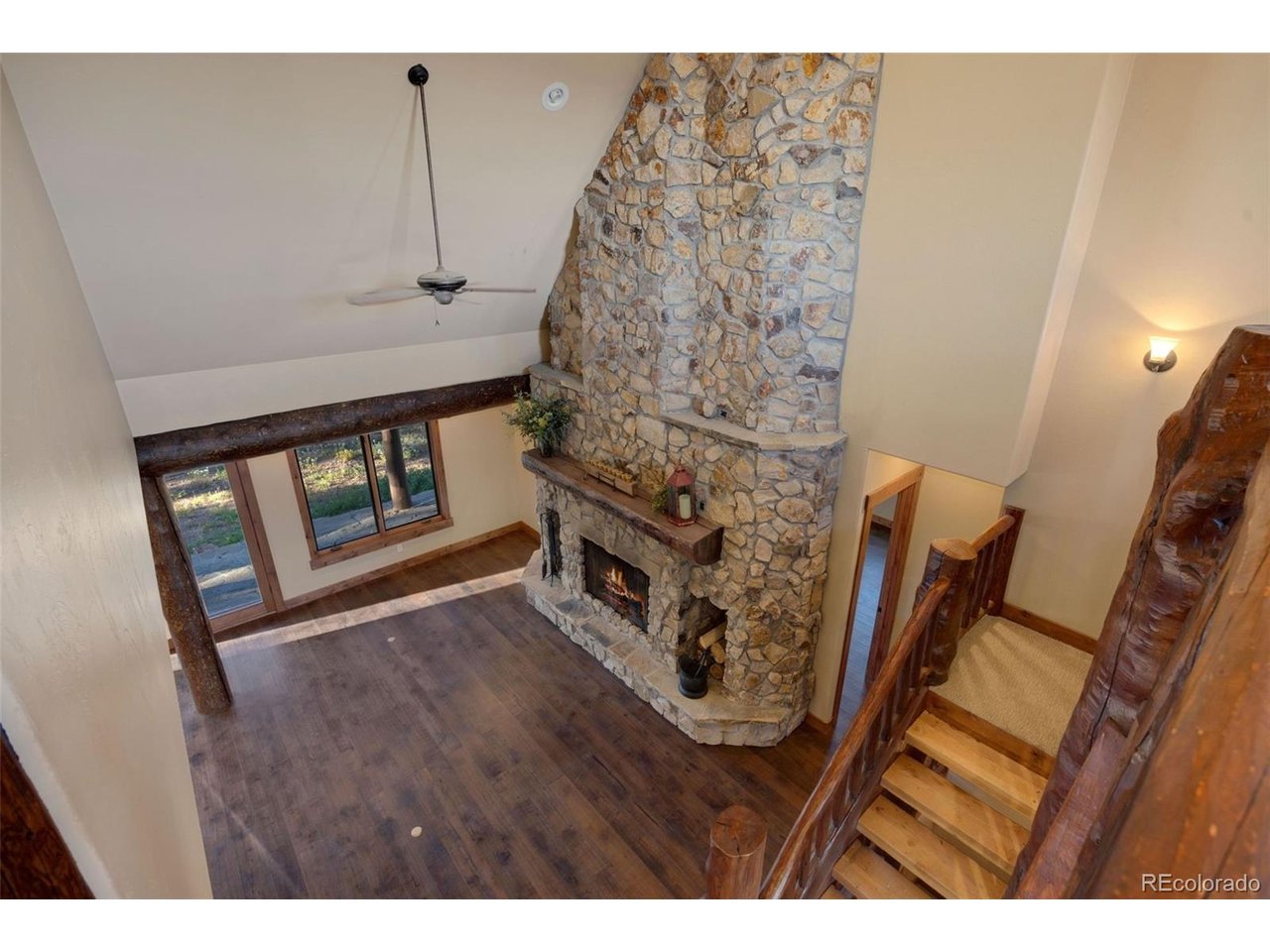 5200 Jackson Road Walden, CO 80480 - Photo 22 of 40 Balcony view of the floor to ceiling fireplace, custom log staircase and high ceilings