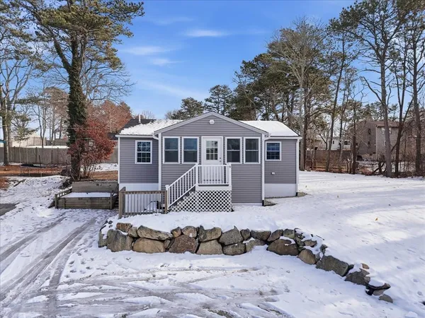 a view of a house with a yard covered in snow