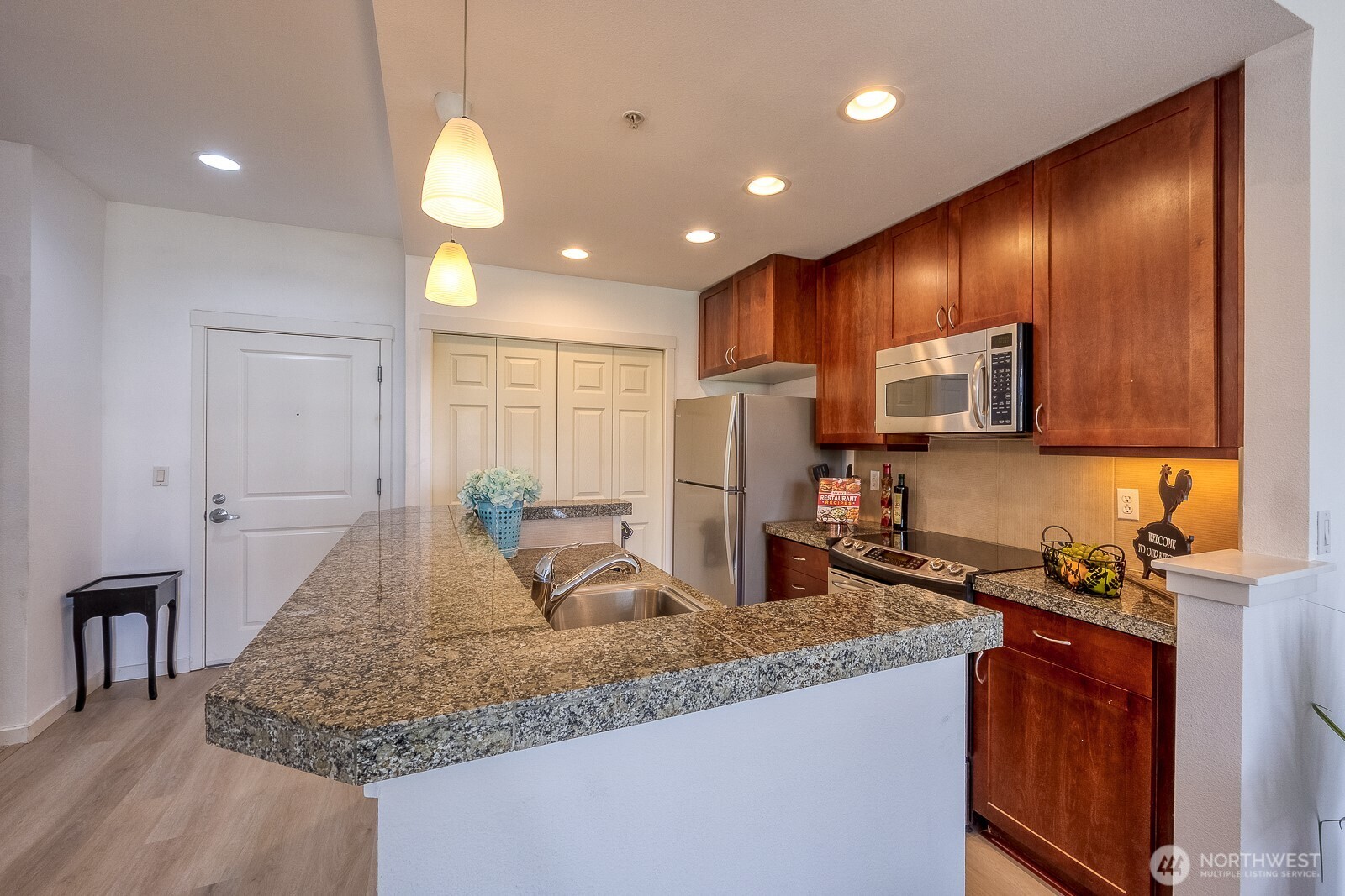 16141 Cleveland Street, Unit 412 Redmond, WA 98052 - Photo 19 of 31 a kitchen with stainless steel appliances granite countertop sink stove refrigerator and cabinets