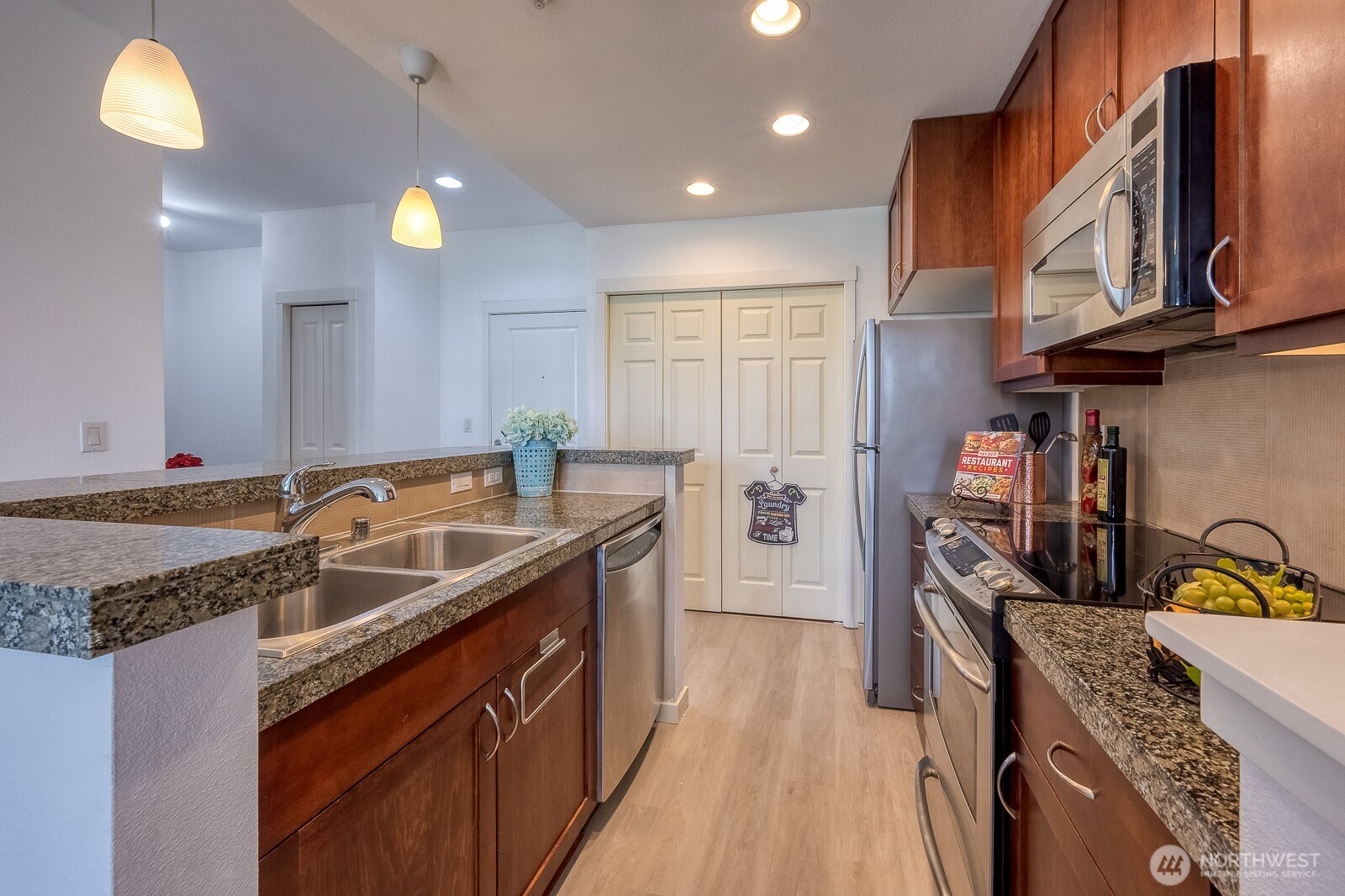 16141 Cleveland Street, Unit 412 Redmond, WA 98052 - Photo 20 of 31 a kitchen with stainless steel appliances granite countertop a sink stove and refrigerator
