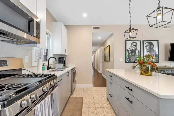 a kitchen with stainless steel appliances granite countertop a sink a stove and cabinets