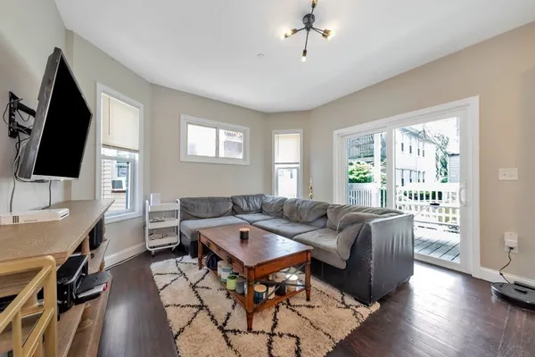 a living room with furniture a flat screen tv and a window