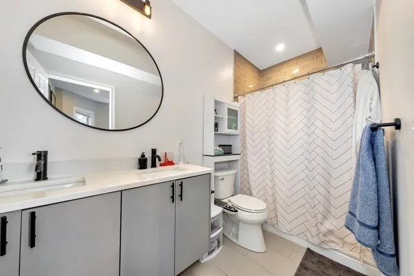 a bathroom with a sink a toilet and a mirror