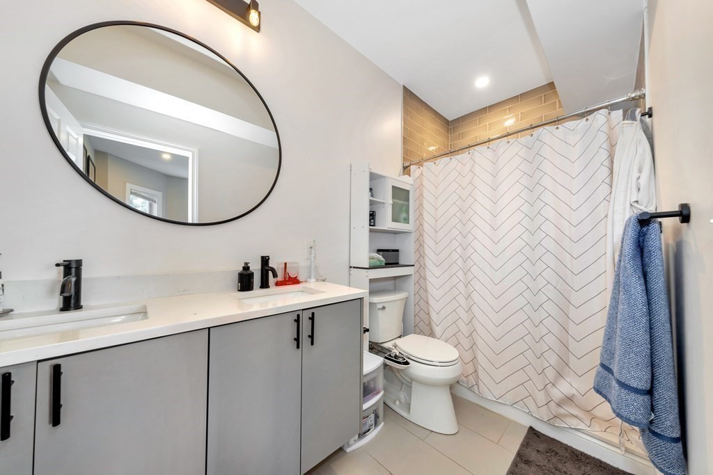 777 Columbia Road, Unit 2 Boston, MA 02125 - Photo 9 of 21 a bathroom with a sink a toilet and a mirror
