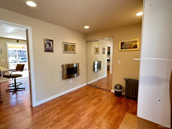 a view of a livingroom with wooden floor and a workspace