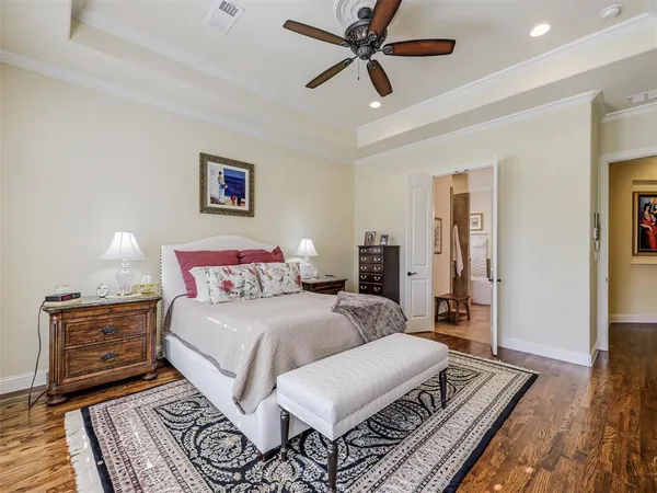 a spacious bedroom with a bed a dresser and a chandelier