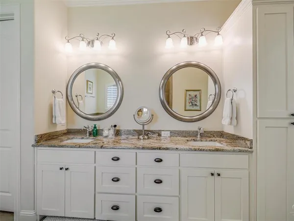 a bathroom with a granite countertop double vanity sinks and a mirror