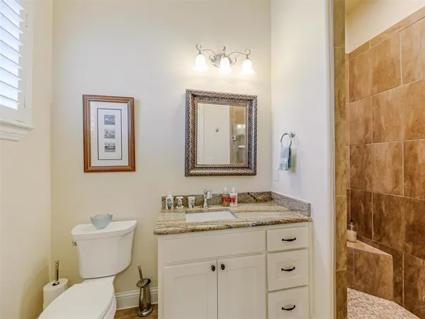 a bathroom with a granite countertop toilet sink and mirror