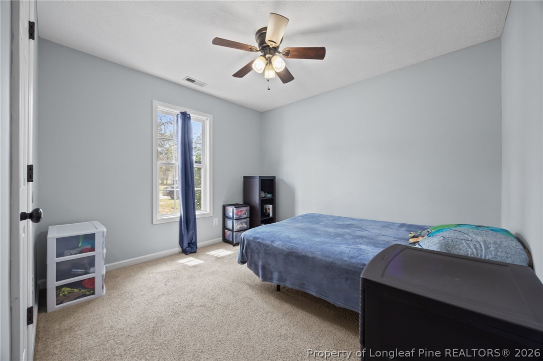 236 Proclamation Drive Raeford, NC 28376 - Photo 11 of 43 a bedroom with a bed and a chandelier