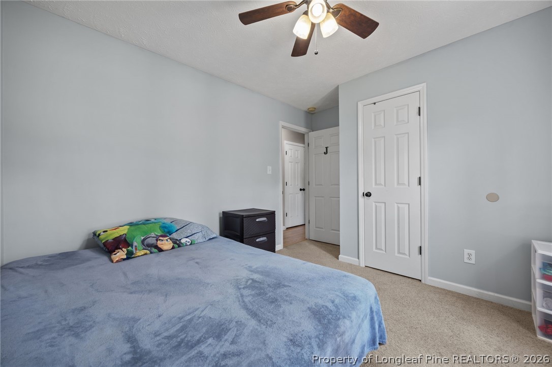 236 Proclamation Drive Raeford, NC 28376 - Photo 12 of 43 a bedroom with a bed and a chandelier