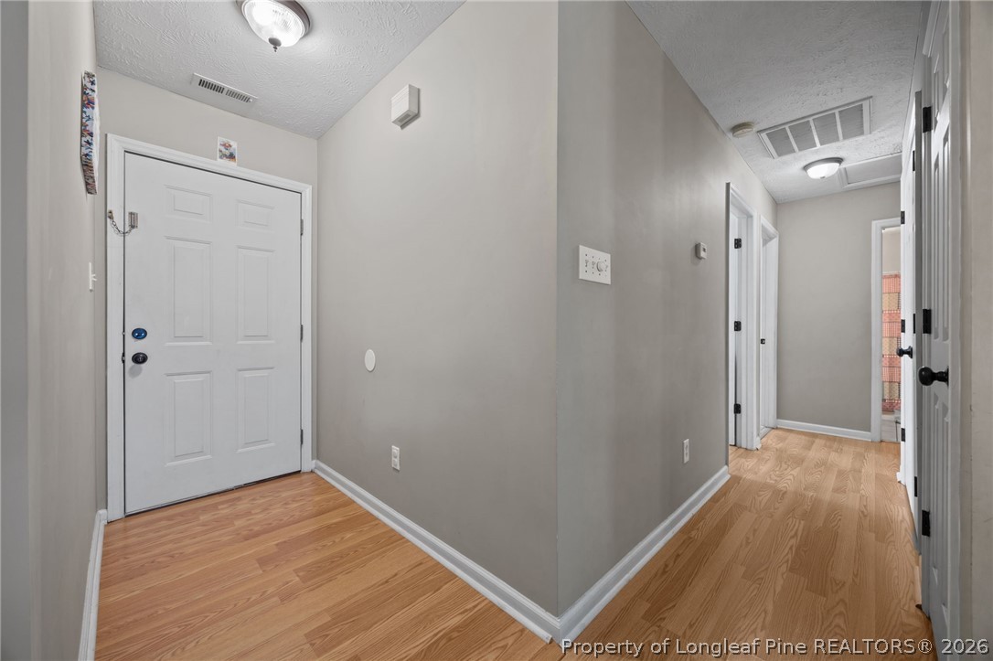 236 Proclamation Drive Raeford, NC 28376 - Photo 15 of 43 a view of a hallway with wooden floor and a bathroom
