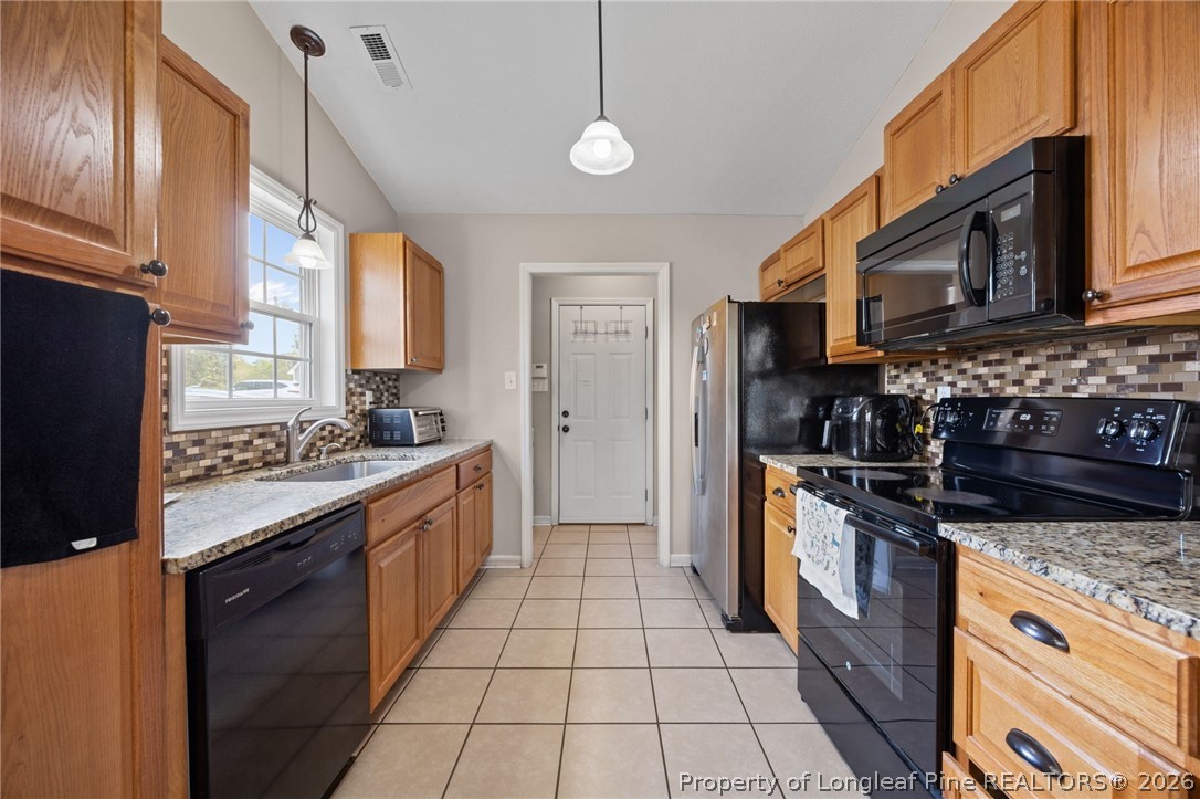 236 Proclamation Drive Raeford, NC 28376 - Photo 25 of 43 a kitchen with stainless steel appliances granite countertop a stove a sink and a refrigerator