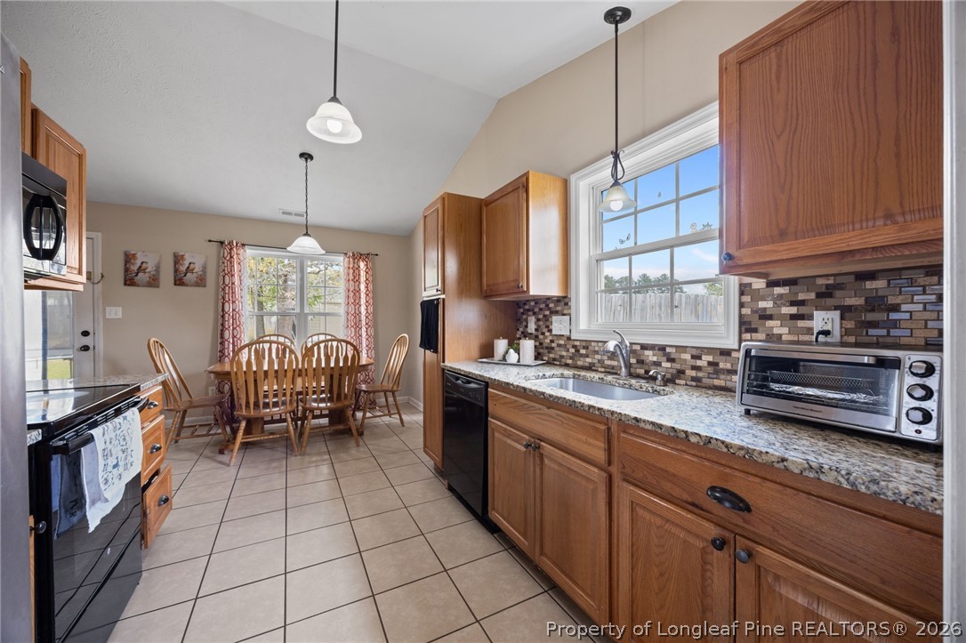 236 Proclamation Drive Raeford, NC 28376 - Photo 28 of 43 a kitchen with granite countertop a stove a sink and a refrigerator
