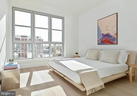 a spacious bedroom with a large bed and a large window