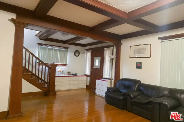 a living room with furniture a flat screen tv and floor to ceiling window