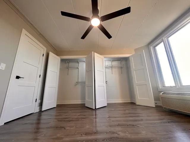 a view of empty room with wooden floor and window