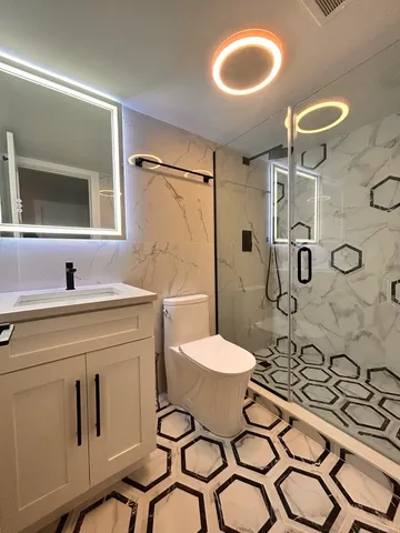 a bathroom with a toilet sink shower and mirror