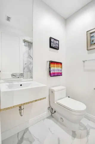 a white toilet sitting next to a bathroom sink
