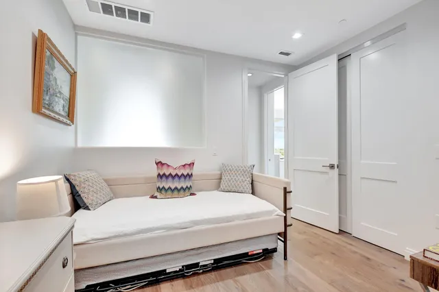 a bedroom with a large bed and wooden floor