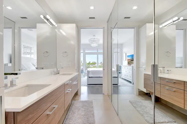 a bathroom with a double vanity sink a large mirror and a bathtub