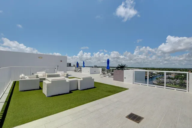 a living room with couches and kitchen view with wooden floor