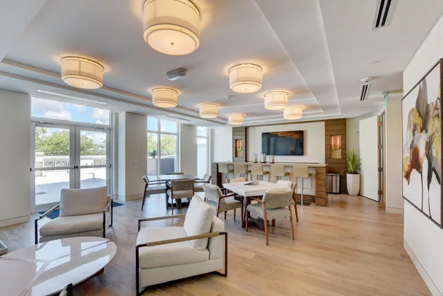a living room with furniture kitchen view and a large window