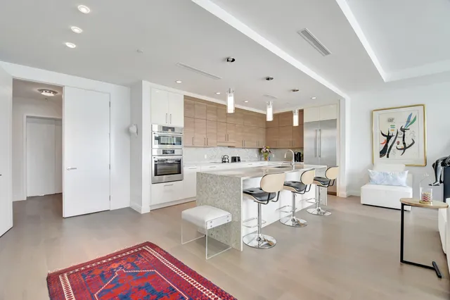a living room with furniture a rug and white walls